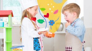 Niño y niña jugando a ser cocineros (jueguetes sin género)